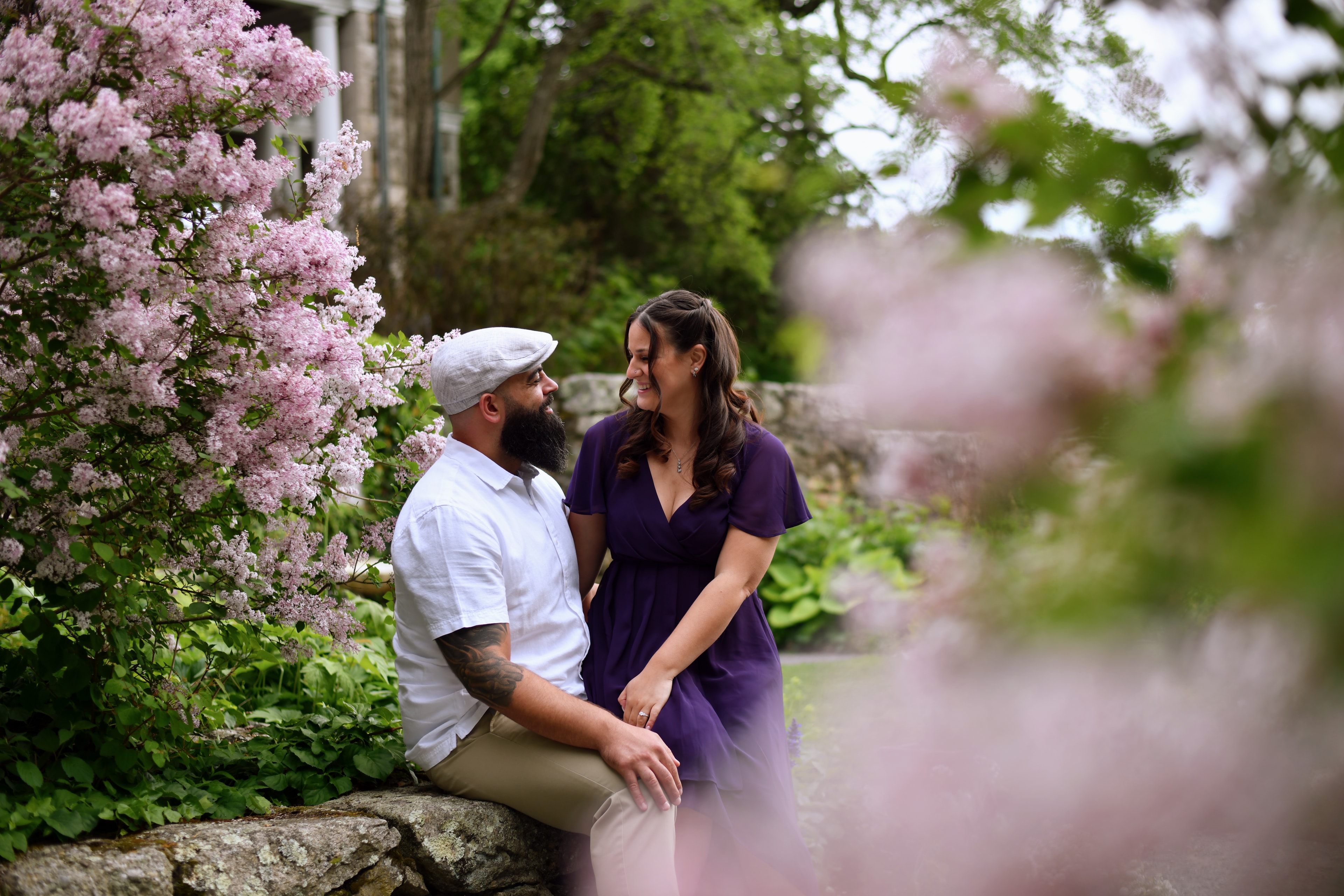 Couple sitting together among lilac blooms